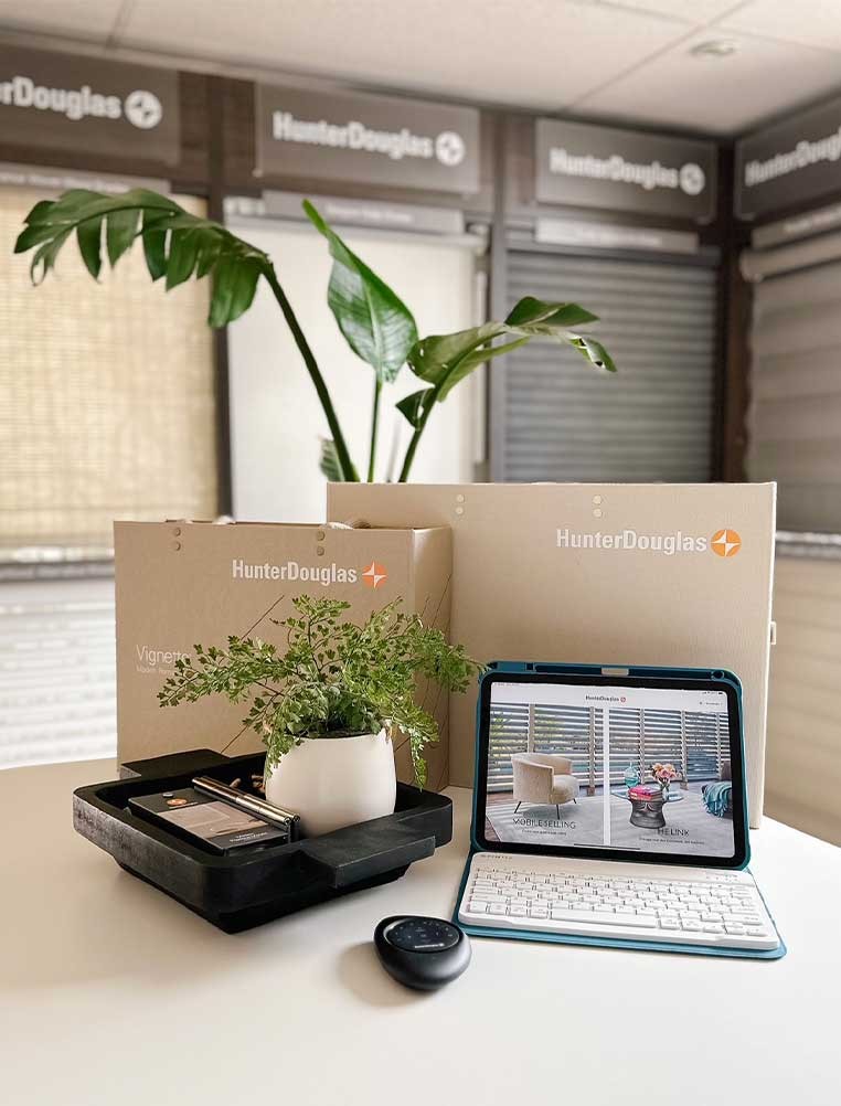 Hunter Douglas products on a desk surrounded by window covering samples
